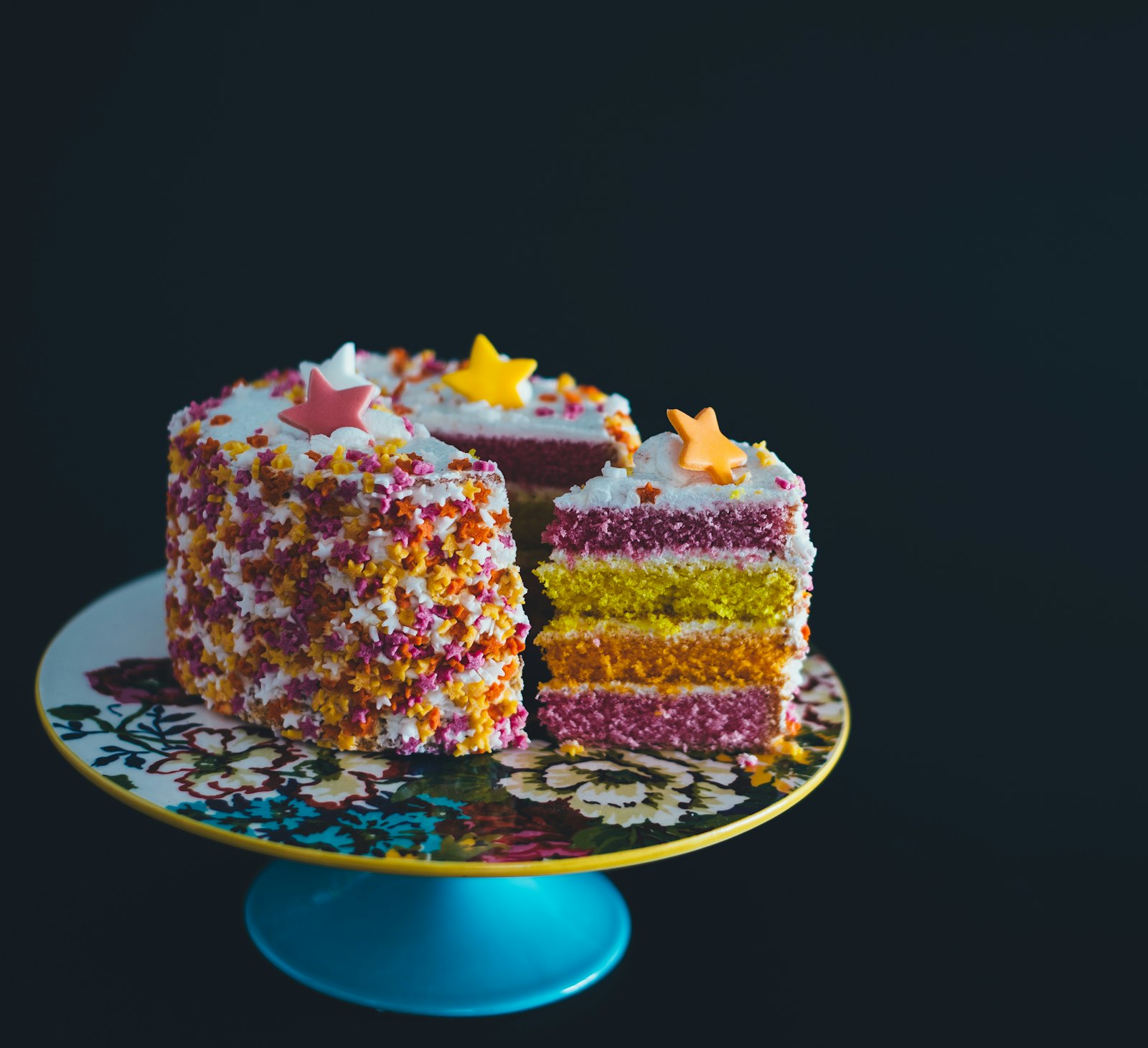 Kue ulang tahun pelangi dengan taburan warna-warni